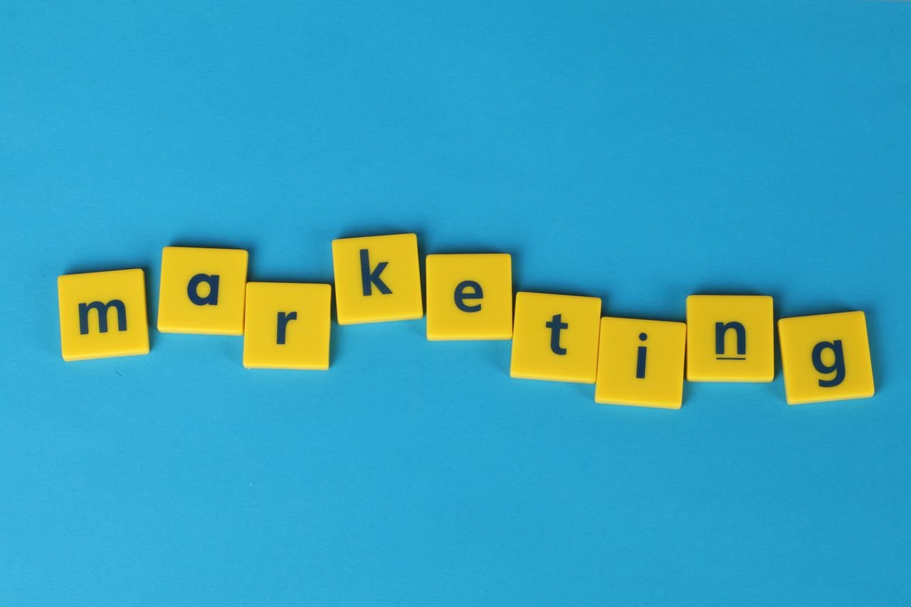 Bright yellow tiles spelling 'marketing' on a blue background, ideal for business themes.