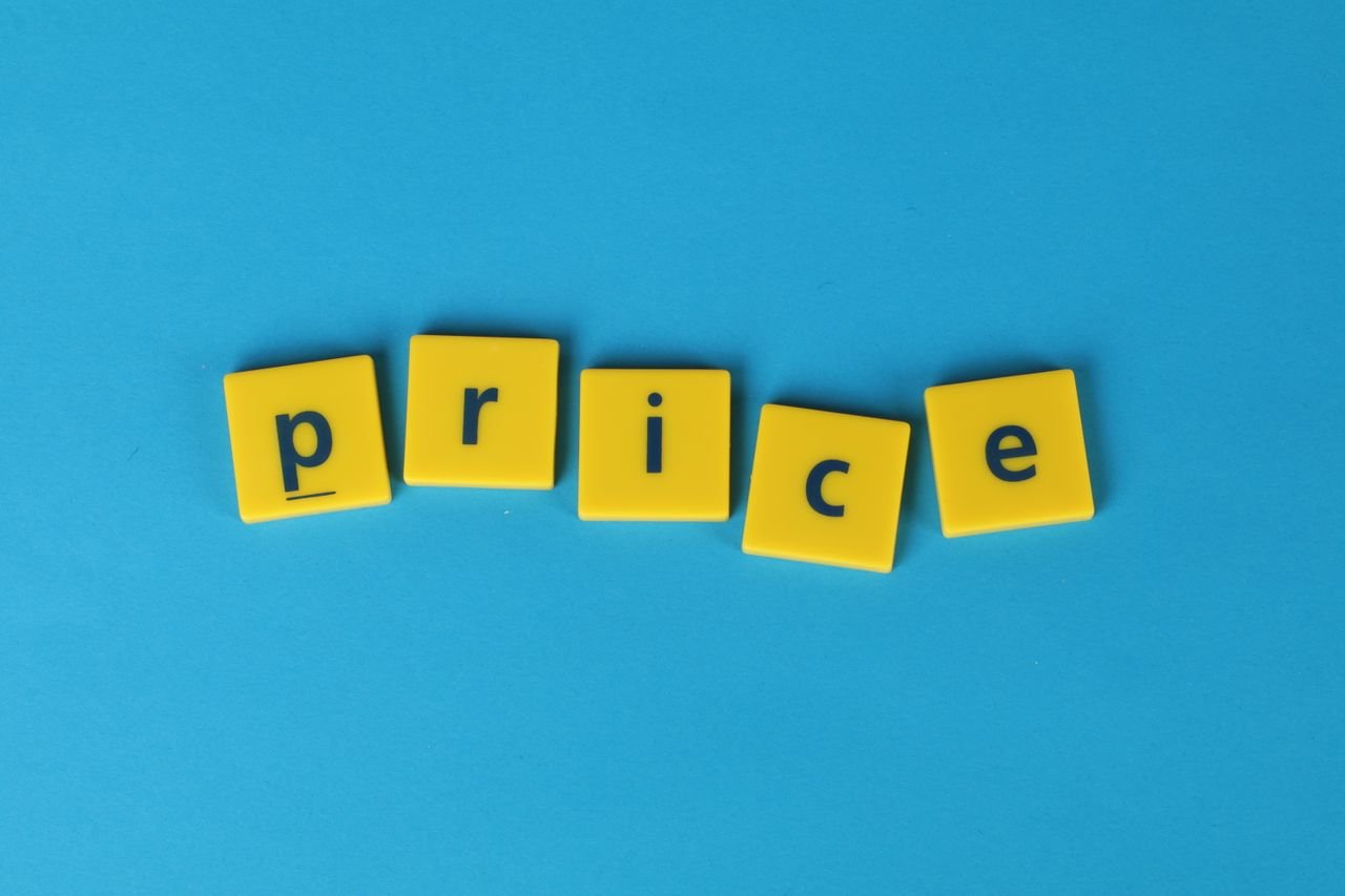 Yellow letter tiles spell the word 'price' against a vibrant blue backdrop, ideal for business concepts.